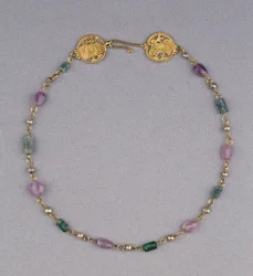 Gold necklace strung with pearls, amethyst and green glass beads with two gold openwork roundels